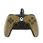 A wired Xbox controller in matte gold and black, featuring the Xbox logo on the center, with the text 'THE COMPETITOR' and 'WIRED CONTROLLER' below on a white background.