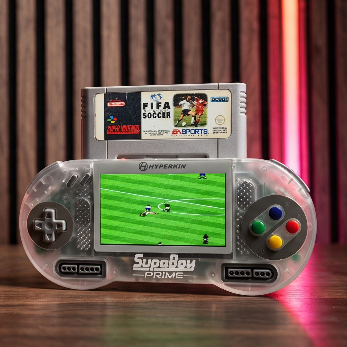 Hyperkin SupaBoy Prime portable console with a cartridge inserted, shown on a wood table with a game on screen