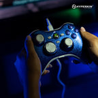 Blue gaming controller held by hands with Hyperkin logo in the corner