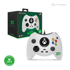 Front view of a white Hyperkin Duke controller for Xbox with its packaging in the background, featuring a large Xbox button, dual analog sticks, D-pad, and colored A, B, X, Y buttons, celebrating 20 years of Xbox.