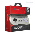 The image shows a Hyperkin Scout Premium Controller for the Super NES. The controller is silver with a black D-pad, two small buttons in the center, and four purple action buttons labeled X, Y, B, and A. The packaging is red and black with the Hyperkin logo and branding.